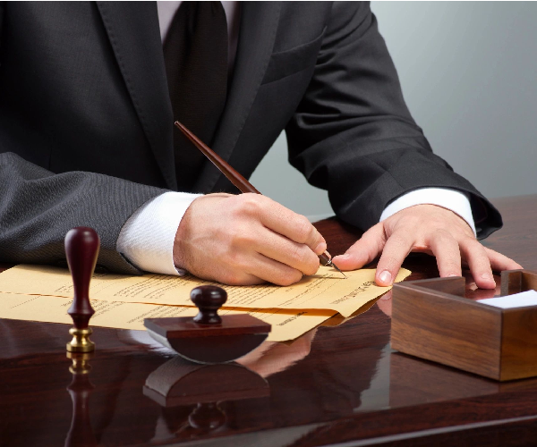 Person signing legal document with fountain pen